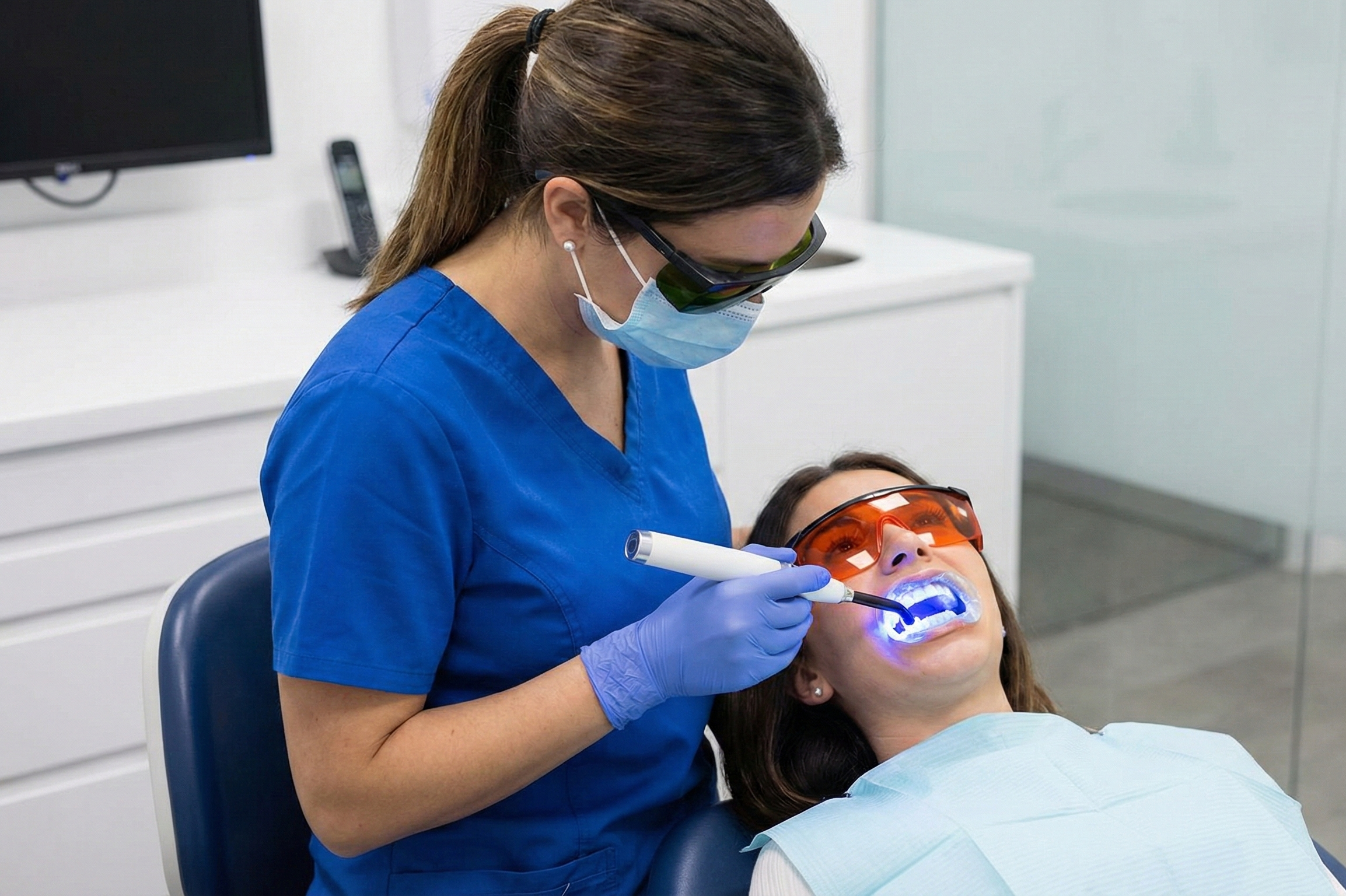 Dentist performing teeth whitening procedure